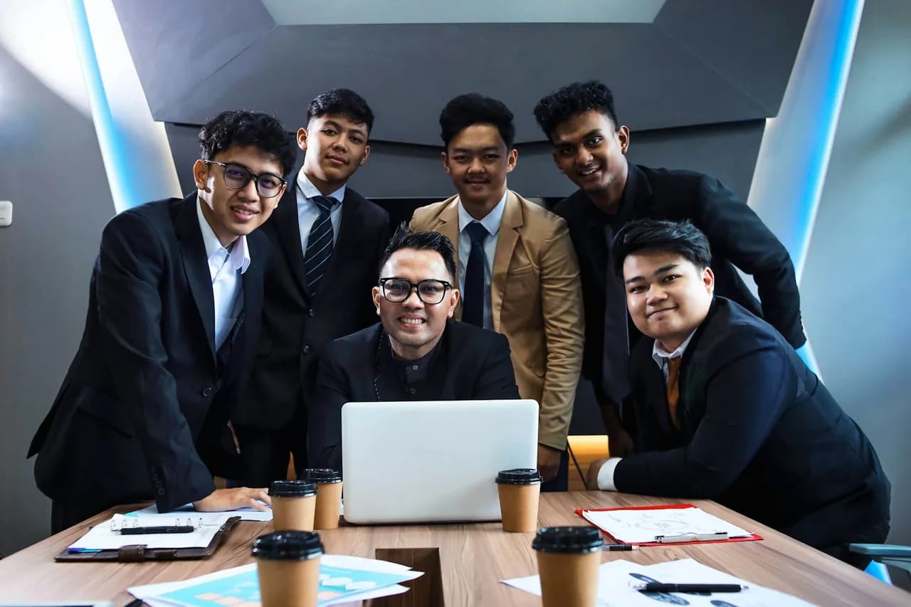 The Netwoorking AI team gathered around a laptop in a meeting room.